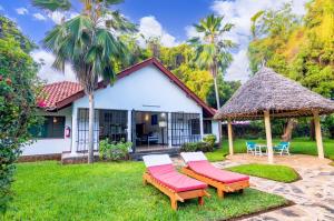 a house with two chairs and a gazebo at Driftwood Beach Malindi Palace in Malindi