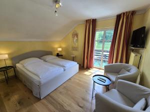 a bedroom with a bed and a chair and a window at Chalet am Kurpark in Boppard