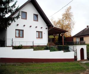 una casa bianca con tetto nero di Erdőszéli Házikó Vendégház a Bükkszék