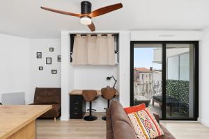 a living room with a couch and a ceiling fan at Comfy Counord place in Bordeaux