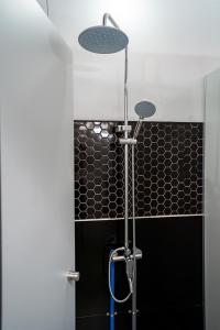 a shower in a bathroom with black tiles at Saigon Box Hostel in Ho Chi Minh City +43 photos