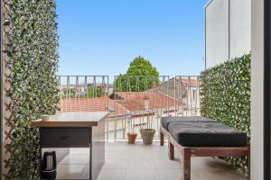 a balcony with a bench and a view of a building at Comfy Counord place in Bordeaux