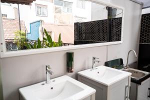 a bathroom with two sinks and a window at Saigon Box Hostel in Ho Chi Minh City
