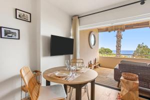 a living room with a table and a view of the ocean at Appt Ramatuelle - Plage Pampelonne in Ramatuelle