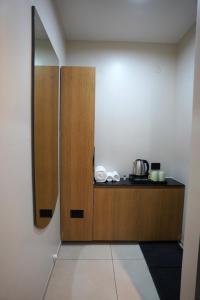 a kitchen with a wooden cabinet and a mirror at TheCloud Hotel in Nizāmābād +10 photos