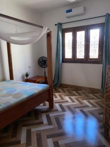a bedroom with a bed and a window at Simai house in Nungwi