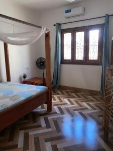 a bedroom with a bed and a window at Simai house in Nungwi
