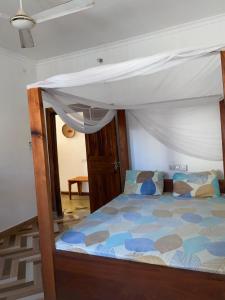 a bedroom with a bed with a canopy at Simai house in Nungwi