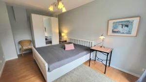 a bedroom with a bed and a table and a mirror at Ferienhaus Friedrich-Borge-Straße in Kühlungsborn