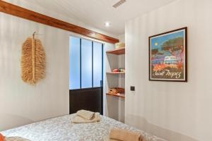 a dining room with a table and a picture on the wall at Appt Ramatuelle - Plage Pampelonne in Ramatuelle
