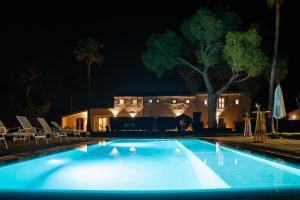 a swimming pool at night with a house in the background at Es Mayolet in Manacor