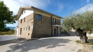 a brick building with a tree in front of it at Country House Altavilla in Altavilla Silentina
