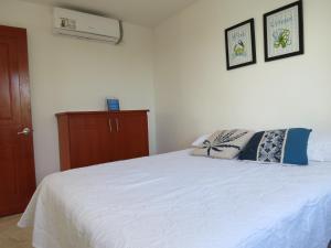 1 dormitorio con 1 cama blanca y 2 almohadas en ZOJO MARiNA BAY, en San Andrés