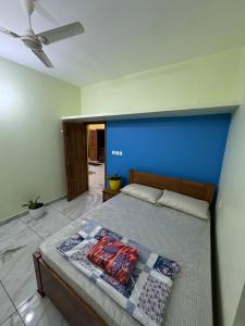 a bedroom with a bed with a blue wall at Mountain pride homestay in Meppādi
