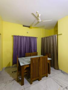 a dining room with a table and a ceiling fan at Mountain pride homestay in Meppādi