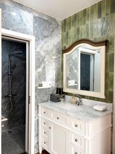 a bathroom with a sink and a shower with a mirror at La Mer Cat Ba Boutique Hotel in Cat Ba