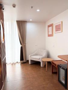 a living room with a chair and a table at La Mer Cat Ba Boutique Hotel in Cat Ba
