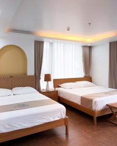 a hotel room with two beds in a room at La Mer Cat Ba Boutique Hotel in Cat Ba