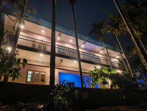 a house with a balcony at night with palm trees at Mountain pride homestay in Meppādi