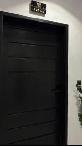 a black garage door with a clock on top at شقة فندقية غرفة نوم وصالة in Hail