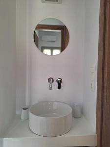 a white bathroom with a sink and a mirror at Smovolo houses 1 in Agios Sostis +10 photos