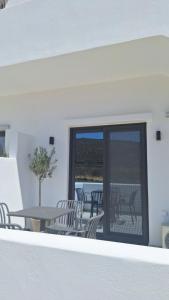 a patio with chairs and a table and a table and a window at Smovolo houses 1 in Agios Sostis