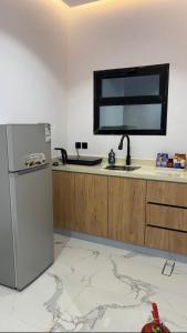 a kitchen with a sink and a refrigerator at شقة فندقية غرفة نوم وصالة in Hail