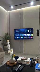 a living room with a tv on a wall at شقة فندقية غرفة نوم وصالة in Hail