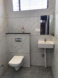 a white bathroom with a toilet and a sink at Raghav Sarkar Parisar in Indore +18 photos