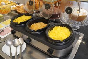 three bowls of food on a counter with pastries at Hotel Pousada Arco Íris Manaira in João Pessoa