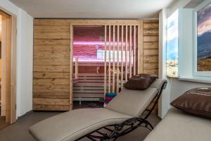 a spa room with a chair and a window at Waldchalets & Ferienwohnungen Allgäu in Burgberg