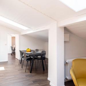 a dining room with a black table and chairs at Apartmenthouse Viktoria in Bern in Bern