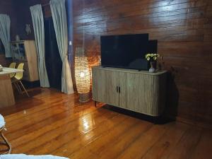 a living room with a television on a wooden floor at Casa do Príncipe in Santo António