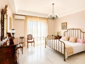 a bedroom with a bed and a chandelier at Avola Garden Apartment near Pantanello Beach in Avola