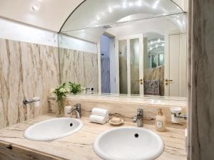 a bathroom with two sinks and a large mirror at Avola Garden Apartment near Pantanello Beach in Avola