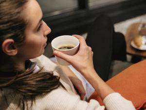 a woman is holding a cup of coffee at ibis budget Berlin Hoppegarten in Hoppegarten +17 photos