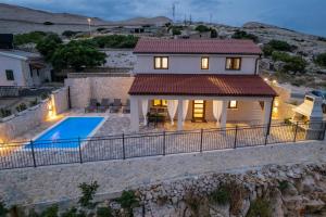 a villa with a swimming pool and a house at Villa Kamia - Luxury seaview villa with private heated pool in Zubovići