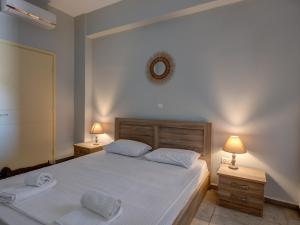 a bedroom with a bed with two lamps and a mirror at Casa Fabrica in Ano Syros