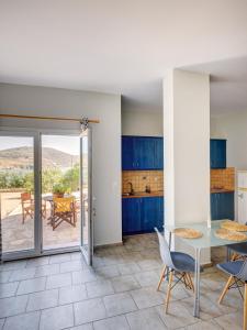 a kitchen with blue cabinets and a table and chairs at Casa Fabrica in Ano Syros
