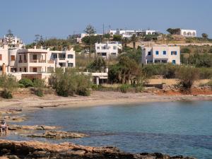 a group of houses on a hill next to a beach at Casa Fabrica in Ano Syros