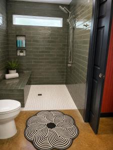 a bathroom with a shower and a swirl rug at Toad-Ally Cozy Cottage - Conway Getaway in Conway