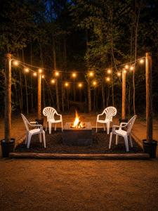 a group of chairs around a fire pit at night at Toad-Ally Cozy Cottage - Conway Getaway in Conway +4 photos