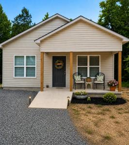 a house with a porch with two chairs and a door at Toad-Ally Cozy Cottage - Conway Getaway in Conway
