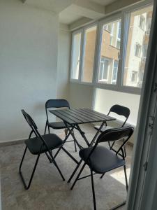 a table and chairs in a room with a window at Soho Studio Fial in Bacău