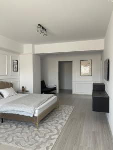 a bedroom with a bed and a chair and a table at Soho Studio Fial in Bacău