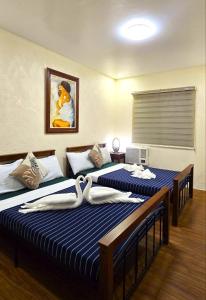 a room with three beds in a room at The Stables by L' Rancho Danilo in Banaba