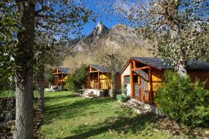 a log cabin with a mountain in the background at Camping Aneto in Benasque