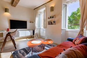 a living room with a couch and a tv at Apt Libelule in Tourrettes-sur-Loup