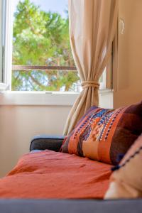 a window with a curtain and a bed in a room at Apt Libelule in Tourrettes-sur-Loup