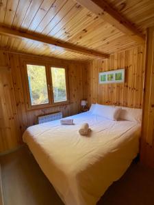 a bed in a wooden cabin with a stuffed animal on it at Camping Aneto in Benasque +135 photos
